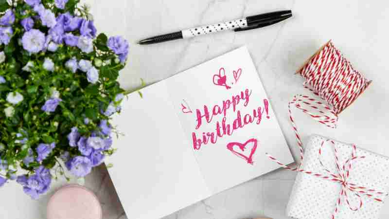 Charming birthday greeting card layout with macarons, flowers, and gift box., tags: ihr - pexel